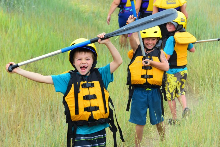 a young boy holding a baseball bat on a field