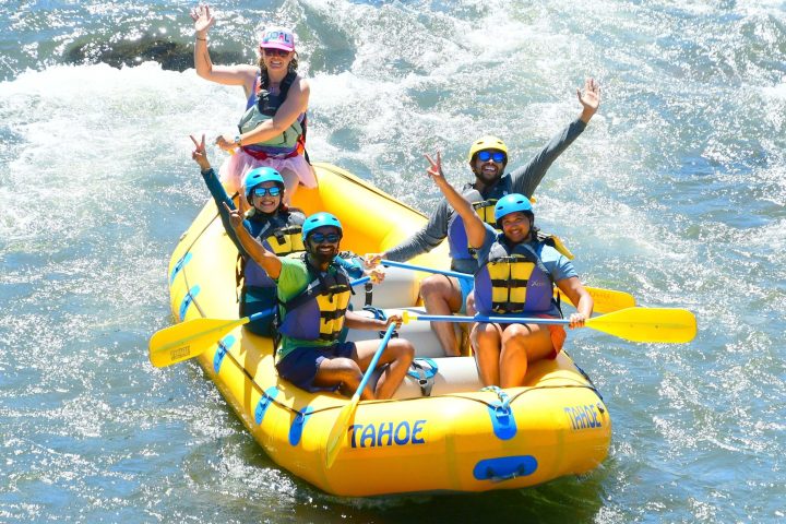 a person riding a surfboard on a raft in a body of water