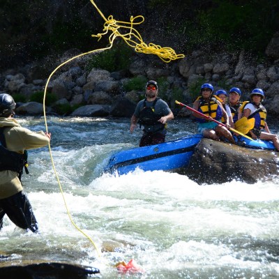 a group of people riding on the back of a boat in the water