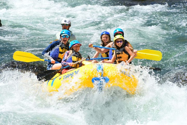 a man riding a wave on a raft in a body of water
